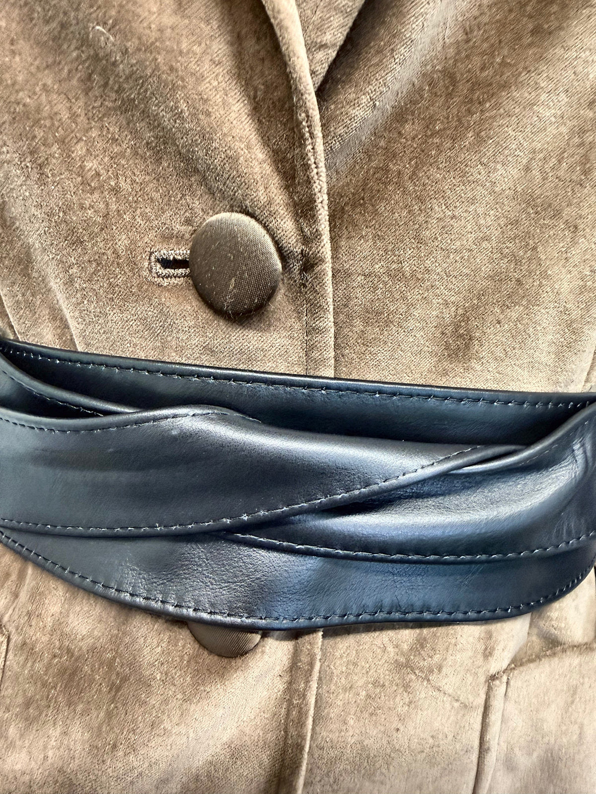 Close-up of the black leather obi belt wrap over a camel velvet blazer