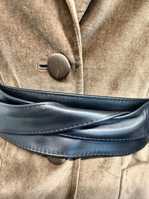 Close-up of the black leather obi belt wrap over a camel velvet blazer