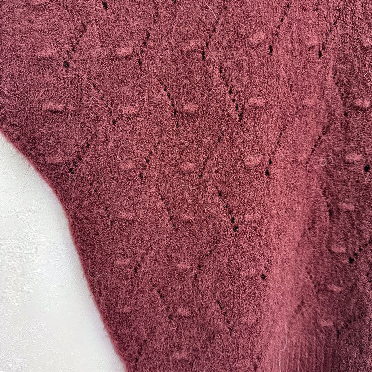 Close-up of Burgundy bobble and pointelle knit texture