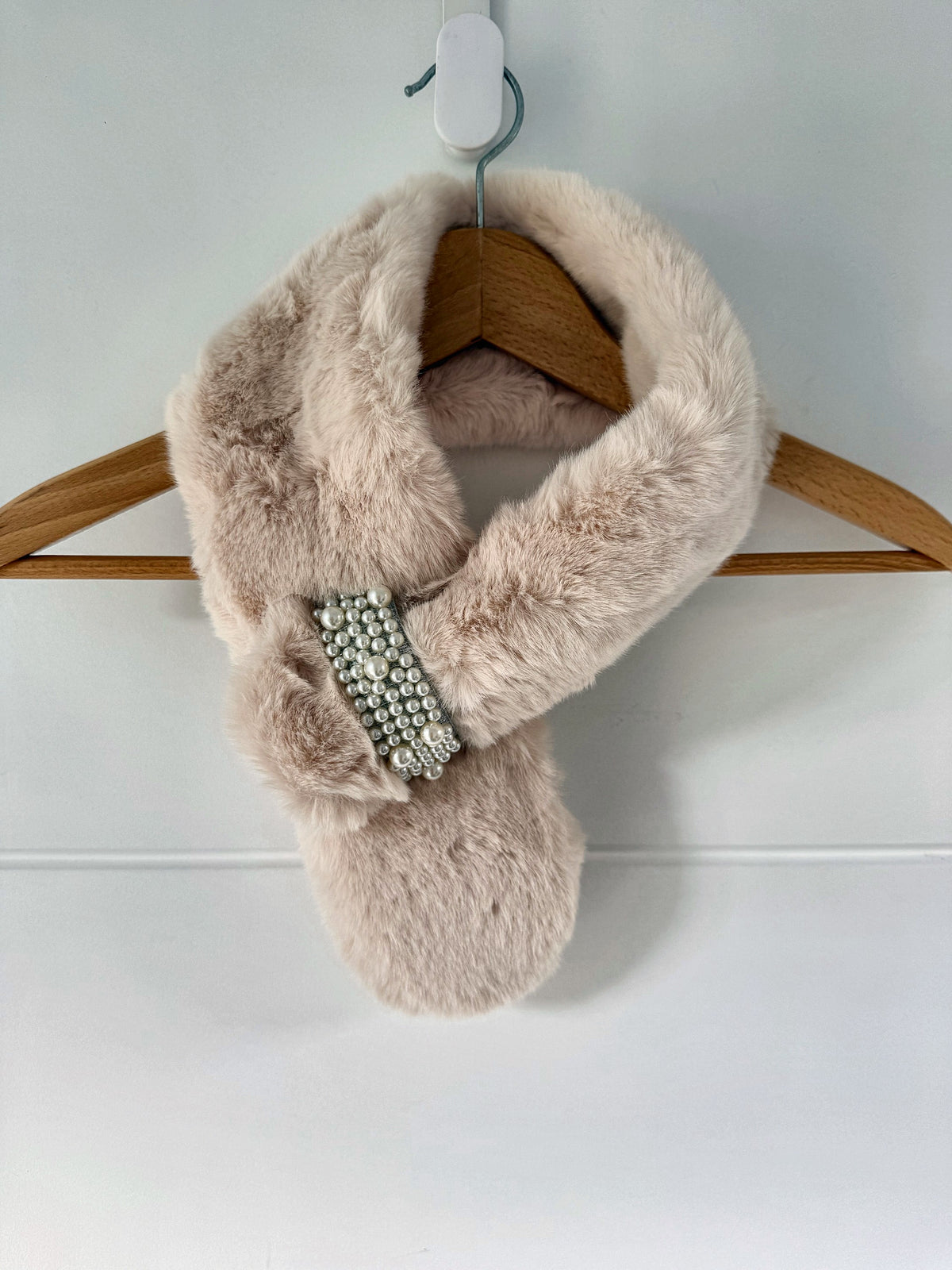 Cream ivory faux fur neck warmer scarf with pearl loop brooch on a hanger