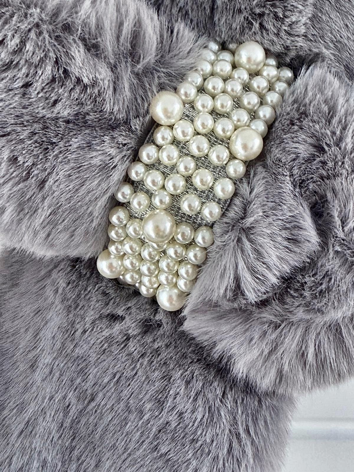 Close-up of the pearl loop brooch on the grey faux fur neck warmer