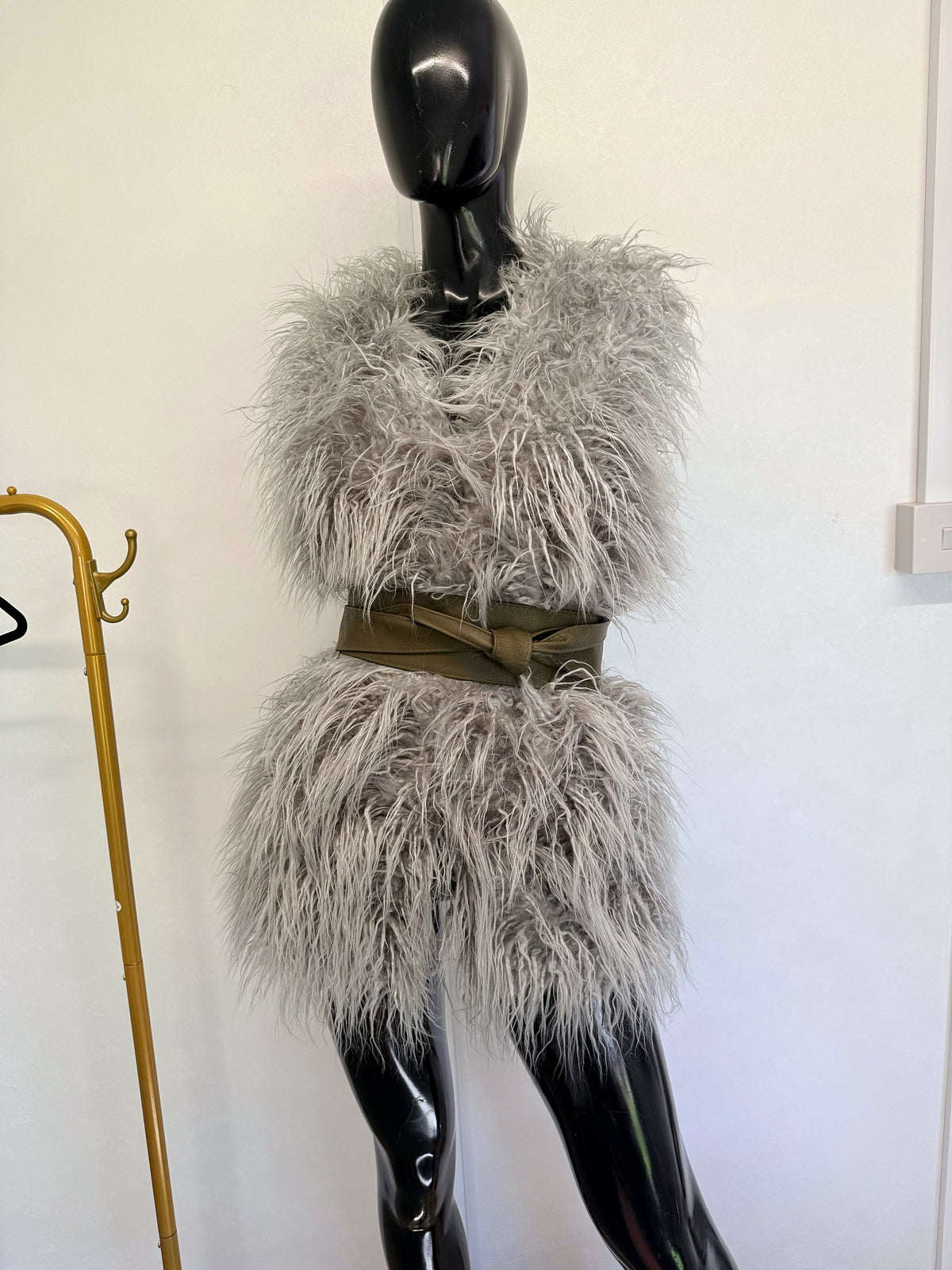 Olive Khaki Green leather obi belt on a grey faux fur gilet, full-length mannequin view