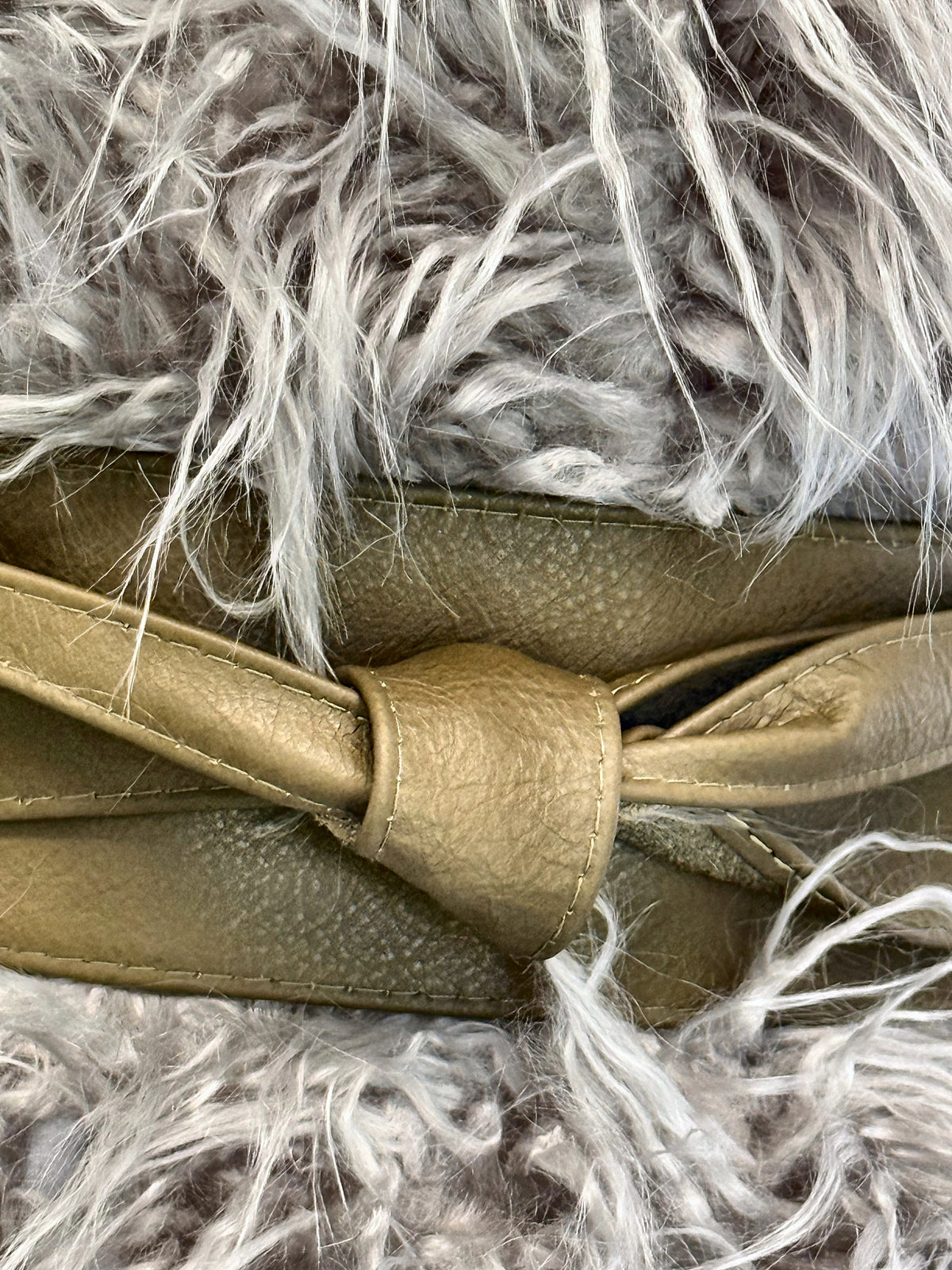 Close-up of the Olive Khaki Green leather obi belt knot over grey faux fur