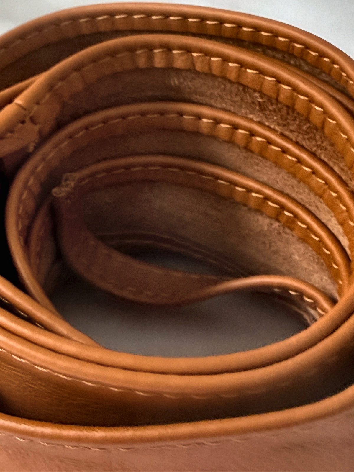 Close-up of the rolled tan Italian leather obi belt showing the stitching